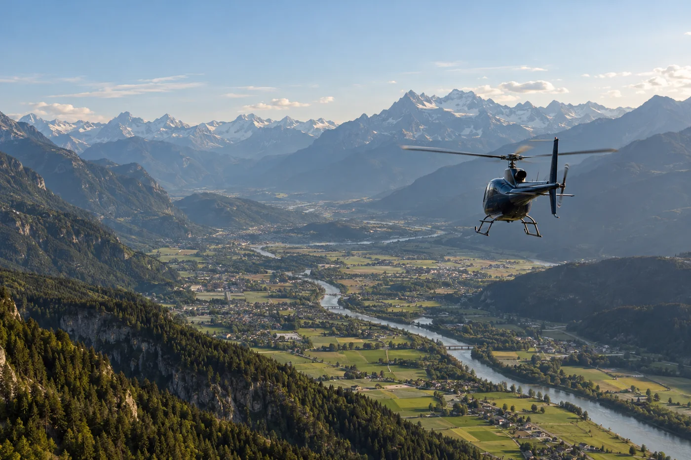Ein Helikopter fliegt über eine weite Alpentalschaft mit Bergen und Feldern.